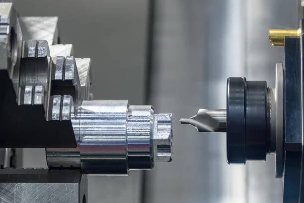 Close-up of CNC turning machining process with a metal part and cutting tool, showcasing precision manufacturing.
