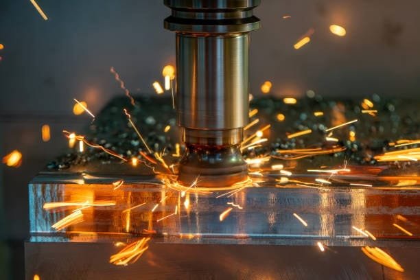 Close-up of a CNC milling machine with sparks flying during the machining of a metal part.