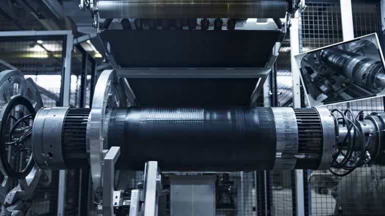 Industrial carbon fiber roll being processed in an automated filament winding or layering machine