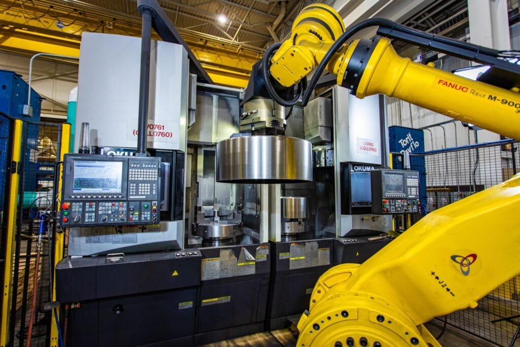 Automated robotic CNC machining cell in aerospace manufacturing facility.