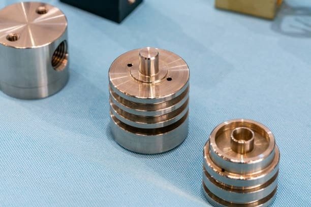 Close-up shot of precision CNC machined metal components with visible fine detailing, showing multiple metallic layers.