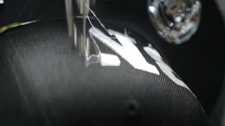 Close-up of embroidery machine stitching on a carbon fiber textured fabric or synthetic blend