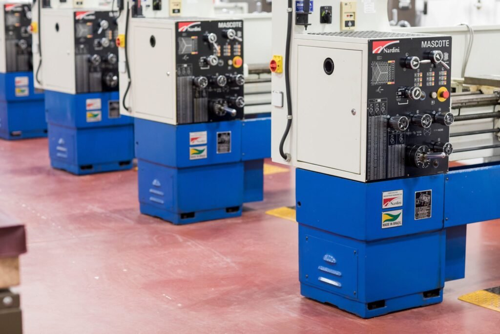 CNC lathe machines with control panels lined up in a manufacturing workshop.