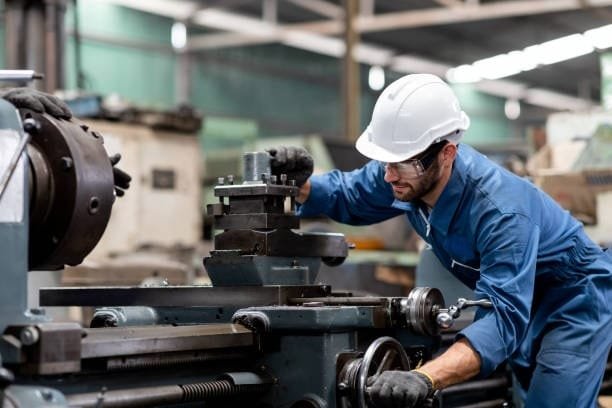Engineer manually adjusting a CNC lathe machine to secure the workpiece, a crucial step before automated cutting begins in CNC machining.