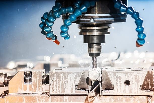 High-speed CNC turning and machining of metal parts with coolant application.