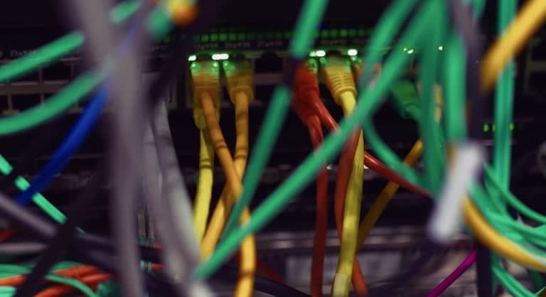 Close-up view of organized data cables connected to a network fixture panel for electrical system testing