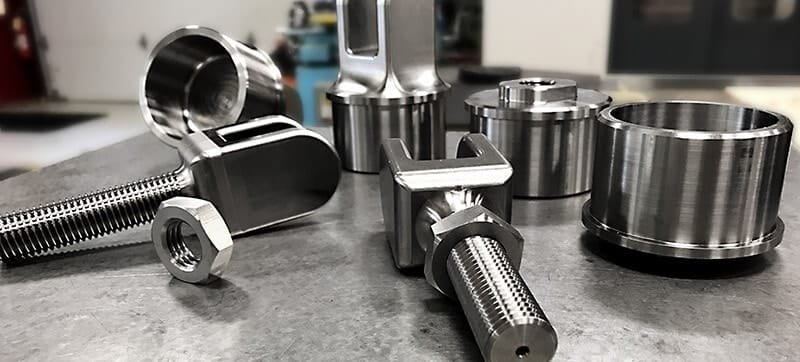 Custom CNC-turned titanium components including bolts and sleeves.