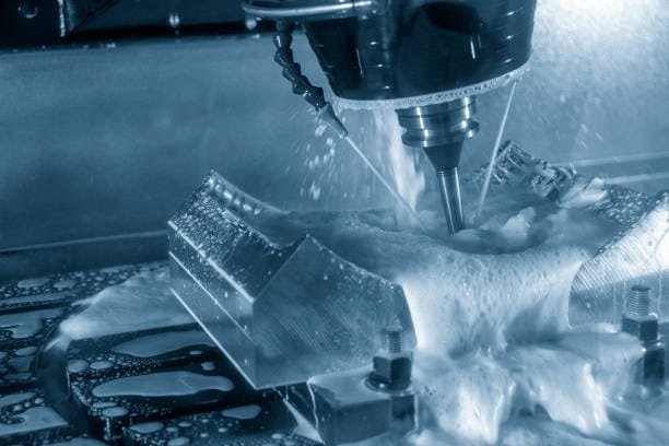 5 axis CNC machine precisely machining a complex part with cooling fluid