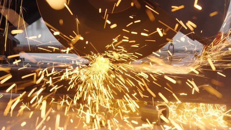 Abrasive cutting machine slicing through metal with intense sparks.
