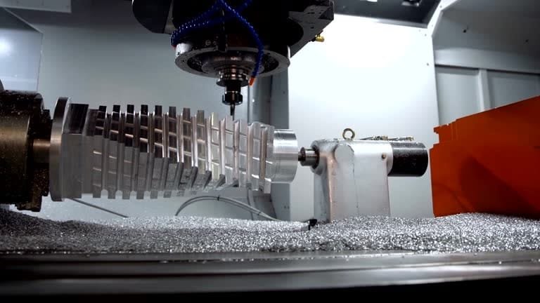CNC 4-axis milling machine using rotary axis to machine an aluminum part with complex grooves