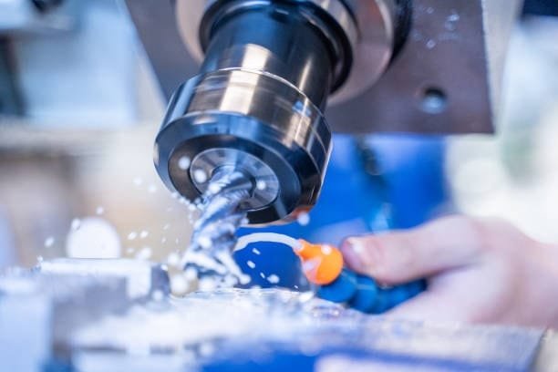 Close-up of cutting fluid application in CNC milling process.