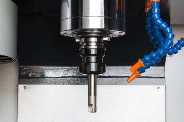Close-up of a CNC 4-axis milling machine spindle head with cooling nozzles for precision machining