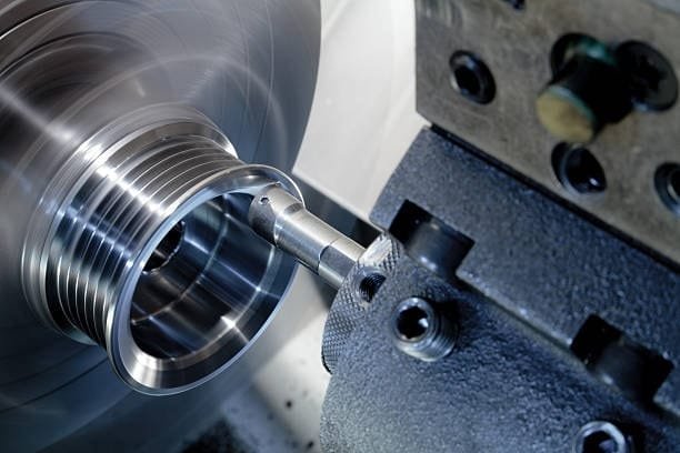 CNC lathe machine turning and shaping a metal ring part.