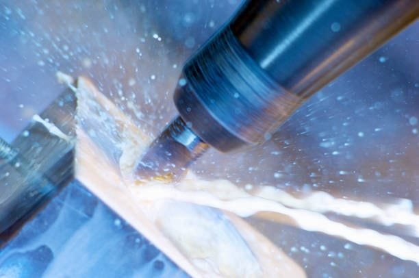 CNC milling tool in action with coolant spraying during machining.