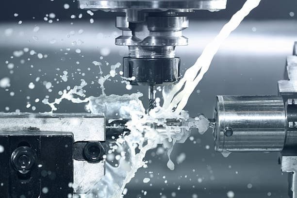 High-pressure coolant spray during CNC machining to reduce heat and friction.