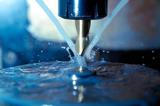 Close-up view of cutting fluid application on rotating tool.
