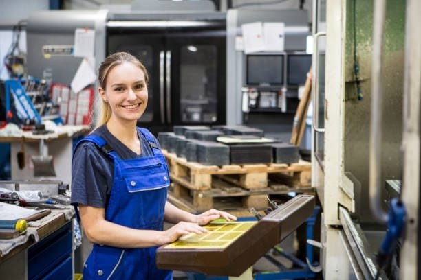 Female CNC machine operator managing milling operations in a factory.