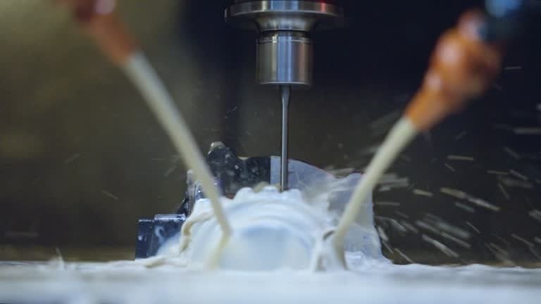 Flood coolant system spraying cutting fluids during CNC milling operation.