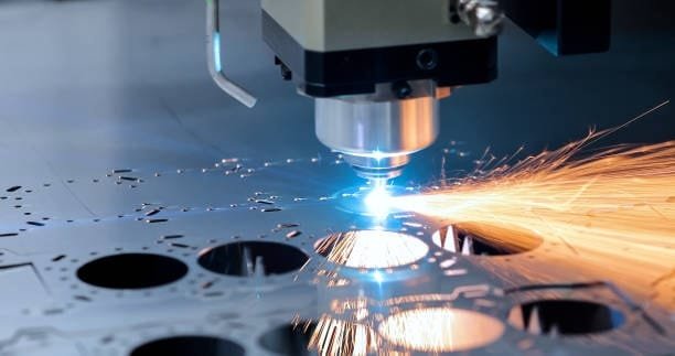 Laser cutting operation on a metal sheet as an advanced CNC machining technique.