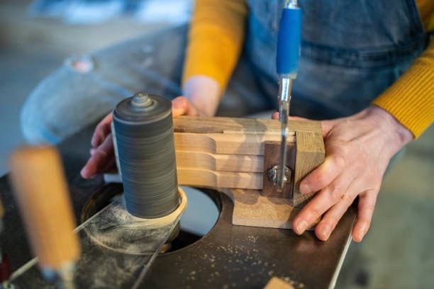 Close-up of a lathe cutting tool shaping a wooden workpiece.