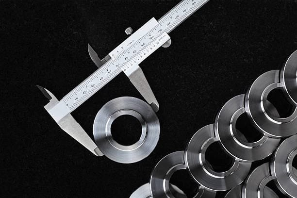 Digital caliper measuring CNC machined parts to ensure accurate machining tolerances.