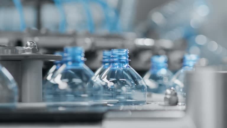 Close-up of plastic bottle necks being formed during plastic manufacturing.