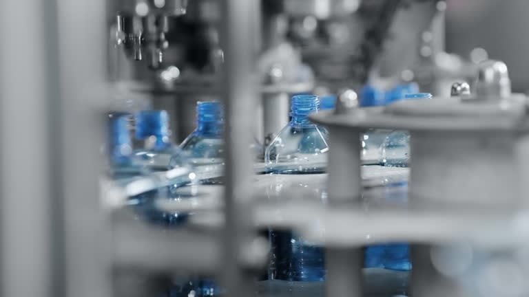 Plastic bottles being filled and sealed during the plastic production process.
