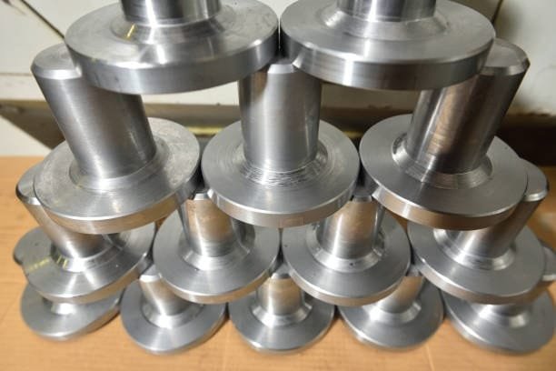 Stack of machined metal parts produced with consistent CNC machining tolerances.
