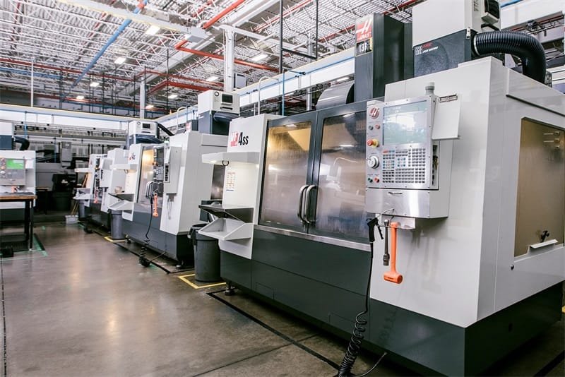 Row of high-precision CNC machining centers operating in a modern workshop