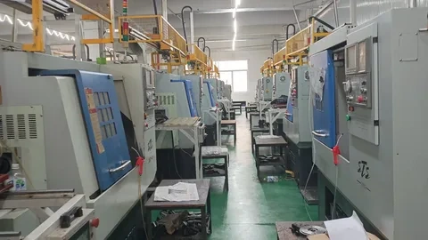 Row of CNC machining centers in a production facility for custom part manufacturing