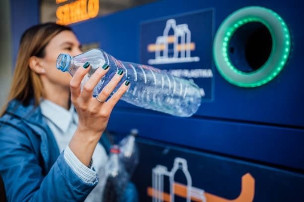 Woman recycling a plastic bottle to support sustainable plastic molding practices