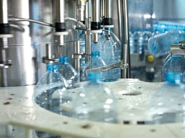 Close-up of plastic bottles being molded in an automated production line for PET containers