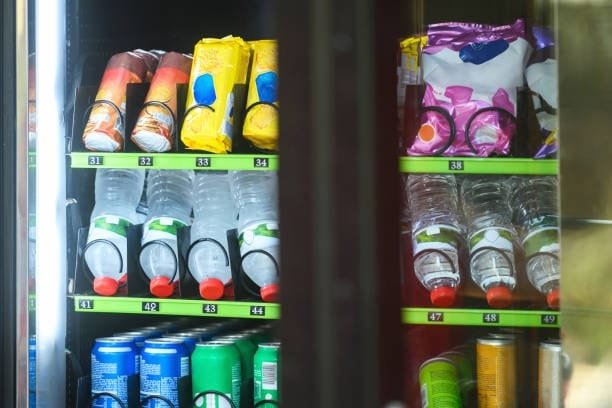 Beverage plastic bottles arranged in a vending machine shelf with packaging examples