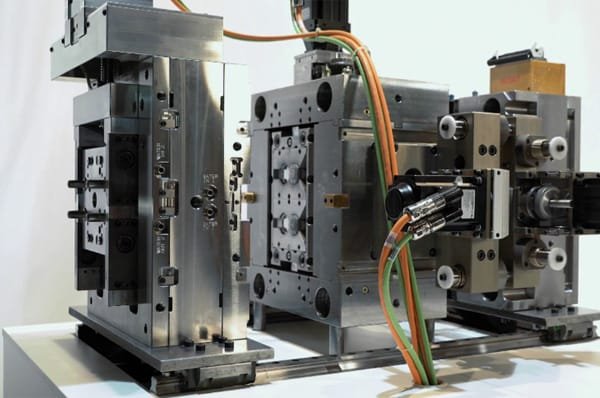 Reaction injection molding machine equipped with aluminum mold tooling and manifold connections