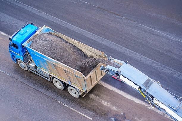Road milling machine transferring removed asphalt to a truck