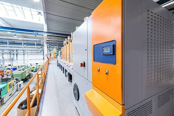 Modern plastic molding production line with colorful industrial machines