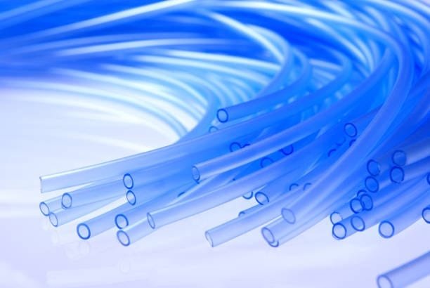Group of blue plastic tubes molded and arranged in parallel formation