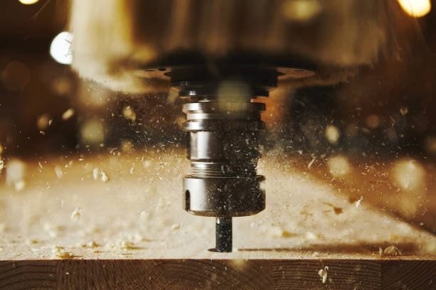 Router bit cutting wood during high-speed CNC operation