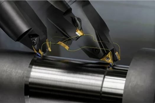 CNC turning center using live tooling to machine a metal shaft with precise cutting inserts