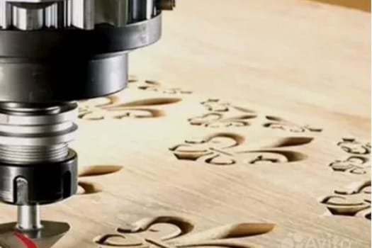 CNC router cutting intricate ornamental patterns into a wood panel