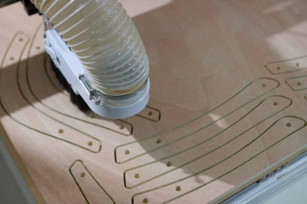 CNC router cutting curved plywood parts on custom-built vacuum table