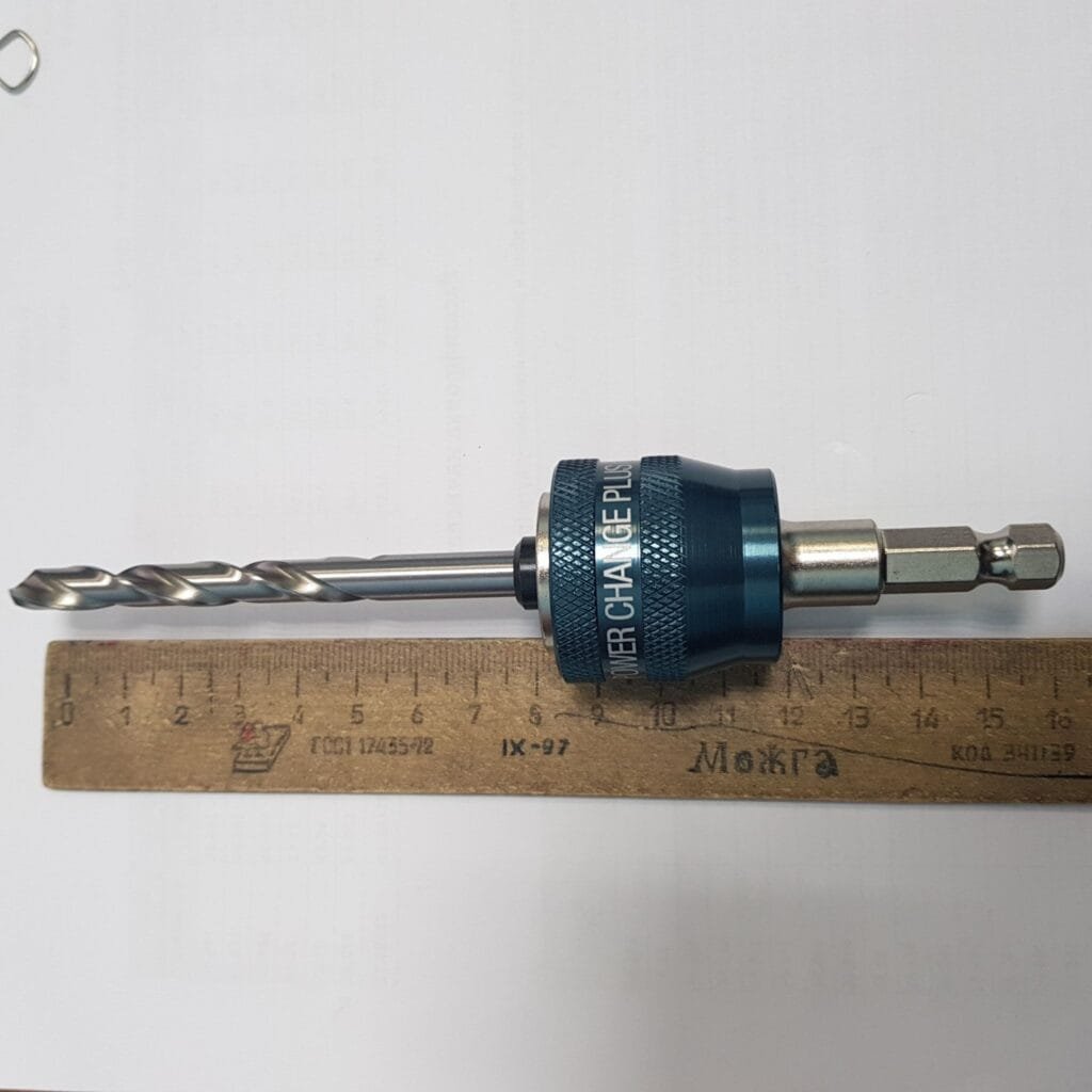Countersink drill bit with quick change adapter placed beside a ruler for scale