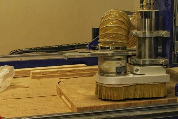DIY CNC router with brush skirt and vacuum dust removal system on plywood
