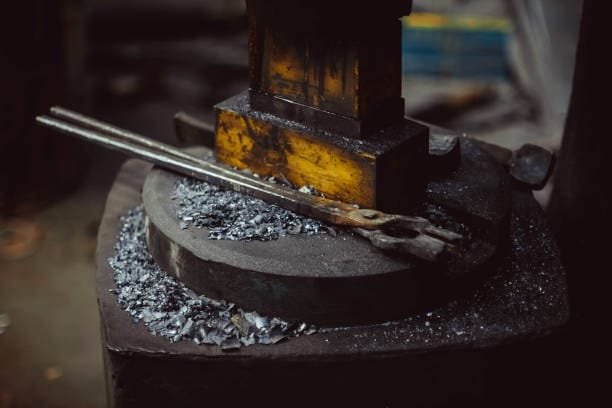Close-up of forging dies surrounded by metal scraps on an anvil surface
