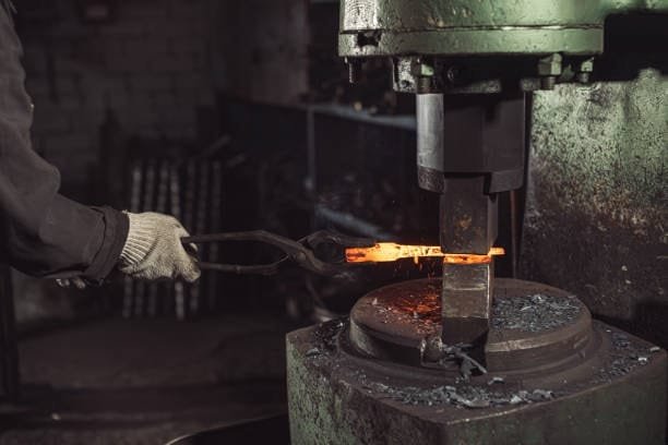 A heavy-duty forging die with scattered metal chips post compression.