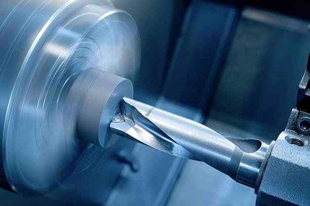 Close-up of high-speed turning operation removing metal in CNC subtractive manufacturing