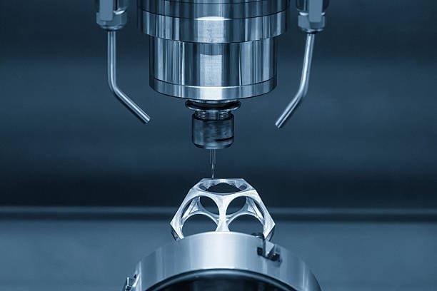 CNC machine with multi-axis setup drilling a hollow, geometric aluminum component.