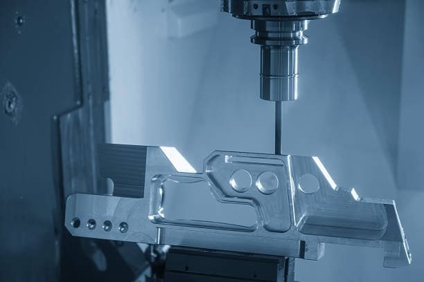Multi-axis CNC machine cutting a complex aluminum component with high precision.