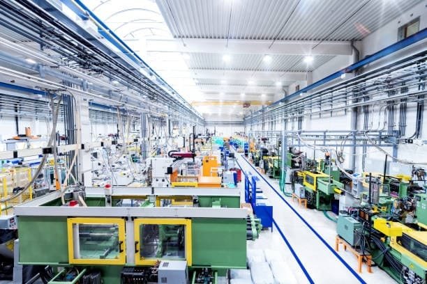 Wide view of a plastic molding factory with injection molding machines in operation