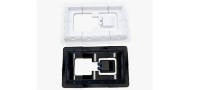 Black and white overmolded part showing a base frame with secondary material insert for combined rigidity and flexibility